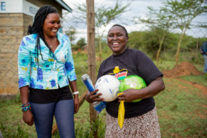 Kenya- Rachel and women with soccer balls smile happy laugh